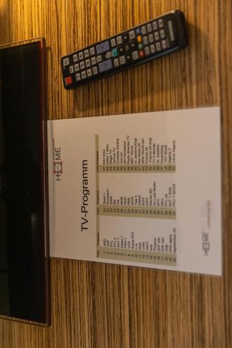 a remote control and a book on a table at Boardinghouse HOME - adults only - in Konstanz