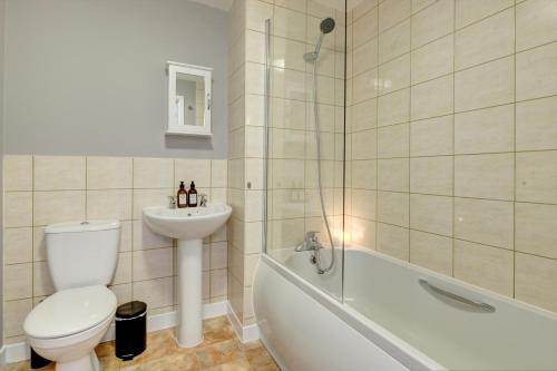 a bathroom with a toilet and a sink and a shower at Tudor Close in Sheffield