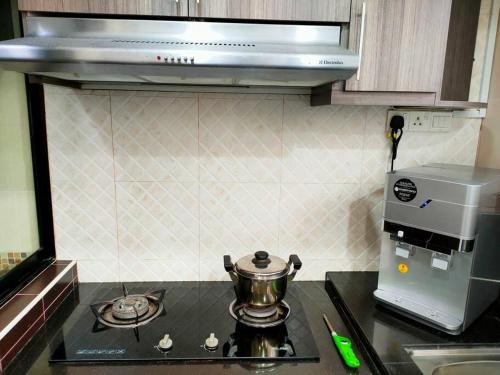 a kitchen with a stove with a pot on it at 678 homestay 4 room 5 minutes to tower in Teluk Intan
