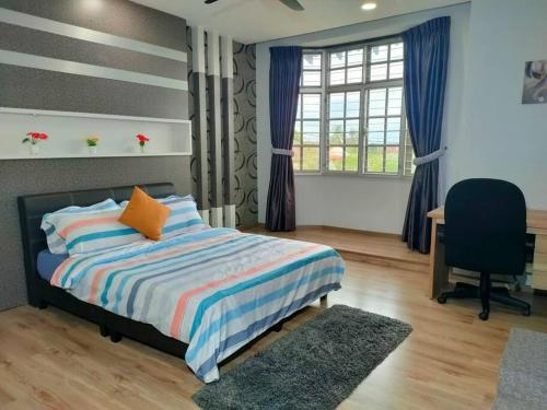 a bedroom with a bed and a desk and a chair at 678 homestay 4 room 5 minutes to tower in Teluk Intan