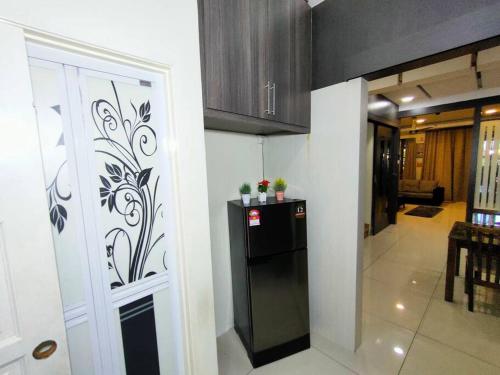 a kitchen with a black refrigerator in a room at 678 homestay 4 room 5 minutes to tower in Teluk Intan