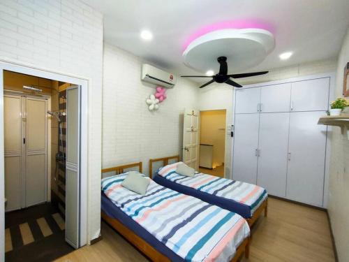 1 dormitorio con 2 camas y ventilador de techo en 678 homestay 4 room 5 minutes to tower, en Teluk Intan