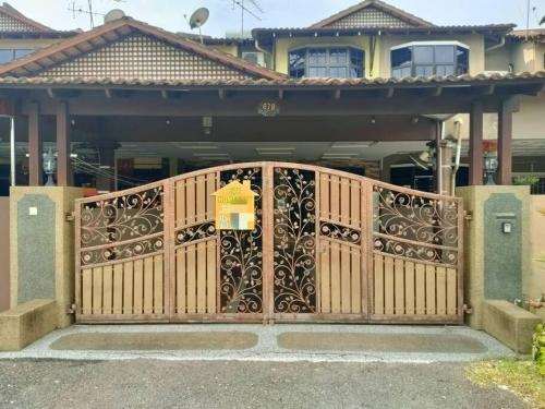 a wooden gate in front of a house at 678 homestay 4 room 5 minutes to tower in Teluk Intan