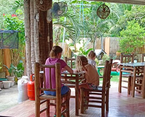 3 enfants assis à une table dans un restaurant dans l'établissement Greenhut Pension & Bar, à Jagna