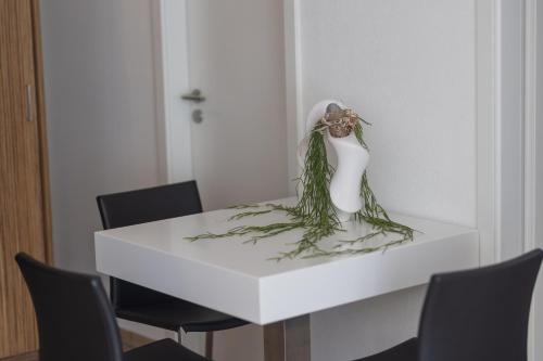 a white table with a vase with flowers on it at Boardinghouse HOME - adults only - in Konstanz