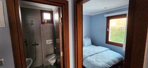 a small bathroom with a bed and a window at Stone House Hotel in Bodrum City