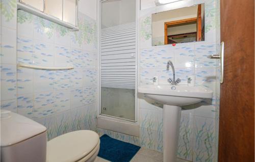 y baño con aseo y lavamanos. en 2 Bedroom Stunning Apartment In Carcheto Brustico, en Carcheto