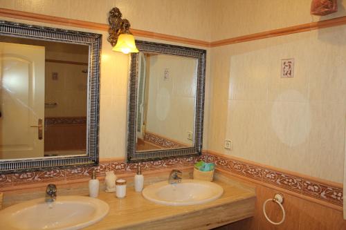 a bathroom with two sinks and a large mirror at Villa Granada Motril in Motril