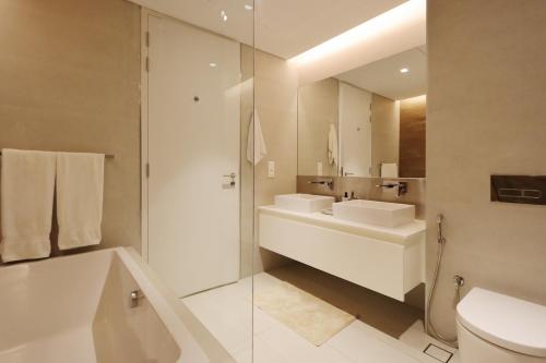 a bathroom with a sink and a toilet and a mirror at Upgraded 2BR Plus Maid's Room with Sea View - Livbnb Bluewaters Suites in Dubai