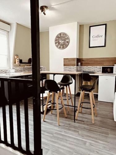 une cuisine avec une table et des chaises et une horloge au mur dans l'établissement Cosy Dunkerquois, à Dunkerque