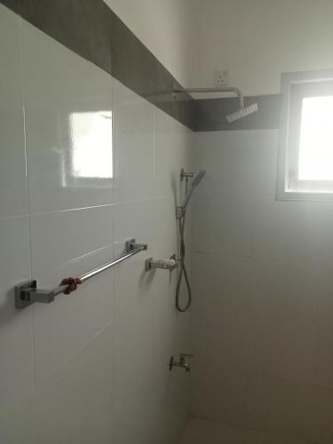 eine Duschkabine im Bad mit Fenster in der Unterkunft Hemali in Galle