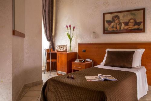 a bedroom with a bed and a table with a clock at Hotel Ciao in Rome