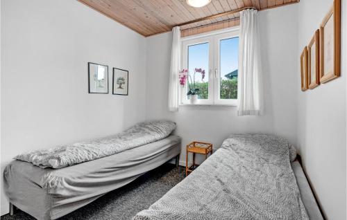 1 dormitorio con 2 camas y ventana en Nice Home In Aabenraa With 2 Bedrooms And Wifi en Åbenrå