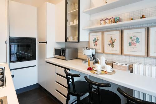 eine Küche mit einer Theke mit Stühlen und einer Mikrowelle in der Unterkunft B&b Piazzetta in Fermo