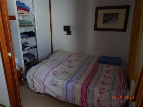 een kleine slaapkamer met een bed in een kamer bij BORSAT 4 in Tignes