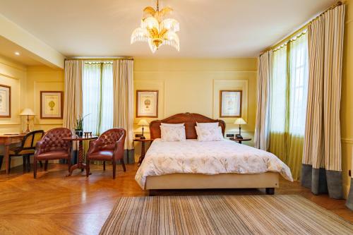 a bedroom with a bed and a table and chairs at Les Jardins d'Anaïs in Luxembourg