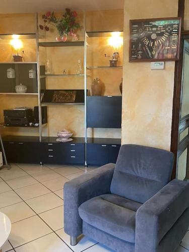un salon avec une chaise bleue et une chaise dans l'établissement maison de campagne, à Trézelles