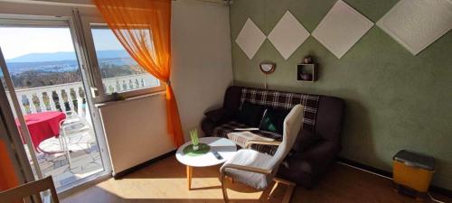 sala de estar con sofá, mesa y balcón en Apartments Berny en Sveti Vid-Miholjice