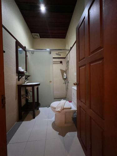 a bathroom with a toilet and a shower and a sink at Luang Prabang Champa Villa Hotel in Luang Prabang