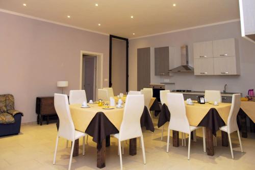 uma sala de jantar com mesas amarelas e cadeiras brancas em Pozzillo San Rocco em Arnesano
