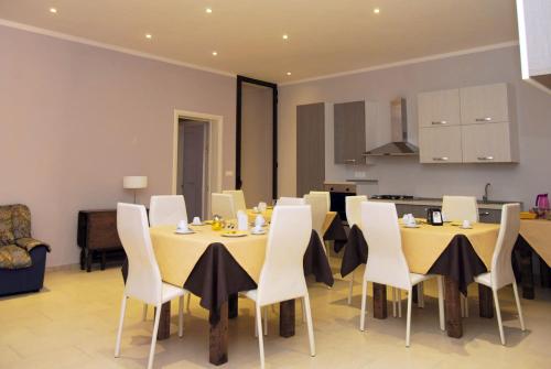 a dining room with yellow tables and white chairs at Pozzillo San Rocco in Arnesano