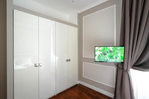 a room with a door and a tv on a wall at B&b Piazzetta in Fermo