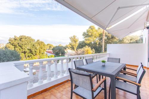 um pátio com uma mesa e cadeiras numa varanda em Villa Xaloc em Cala Galdana