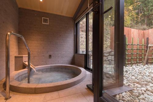 日光的住宿－Nikko Nishimachi Club，带窗户的客房内的热水浴池