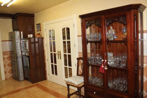a kitchen with a large wooden cabinet filled with glasses at Villa Granada Motril in Motril