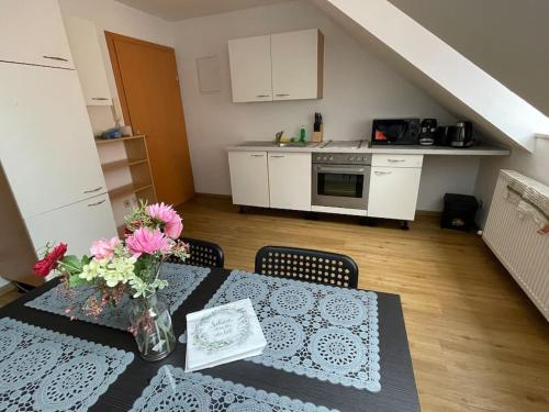 - une cuisine avec une table et des fleurs dans l'établissement StayEasy Apartments Graz A6, à Graz