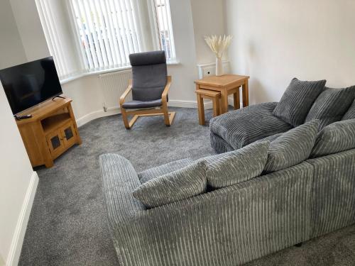 a living room with a couch and a chair at Cheshire Home Stays in Church Coppenhall