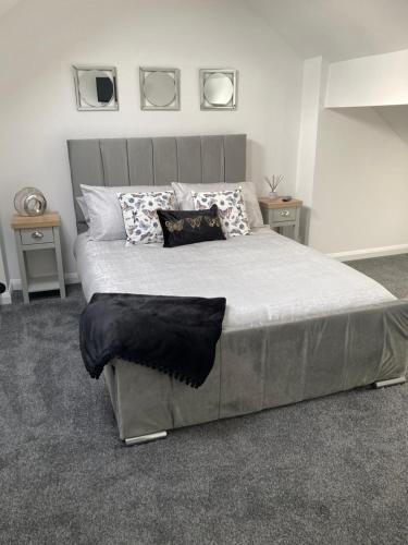 a bedroom with a large bed with two tables at Cheshire Home Stays in Church Coppenhall