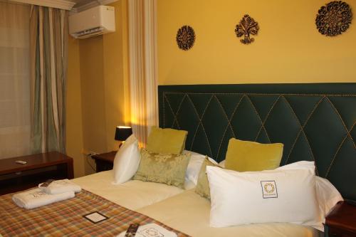 a hotel room with a bed with white pillows at Villa Granada Motril in Motril