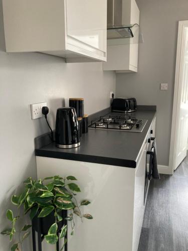 a kitchen with a black counter top and a stove at Cheshire Home Stays in Church Coppenhall