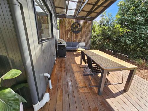 a wooden deck with a picnic table and a grill at Melazzano in Lilydale