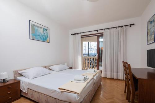a bedroom with a bed and a desk and a television at Villa Tramontana in Krilo