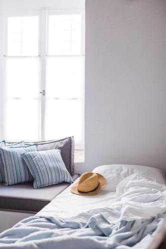 a hat is sitting on top of a bed at Keresbino Hydra Manor House in Hydra