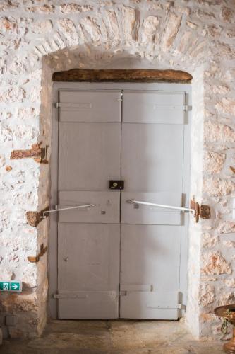a large white garage door in a brick wall at Keresbino Hydra Manor House in Hydra
