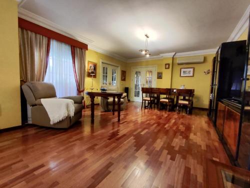 a living room with a hard wood floor and a dining room at Villa Granada Motril in Motril