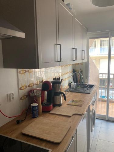 une cuisine avec des armoires blanches et un comptoir en bois dans l'établissement Charmant T1 Bastia, à Bastia