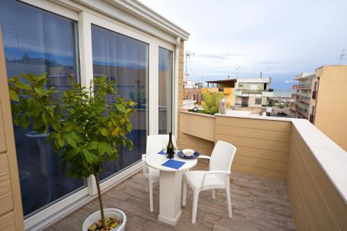 a balcony with a table and chairs on a balcony at Sopravento Apartments - Margherita di Savoia in Margherita di Savoia
