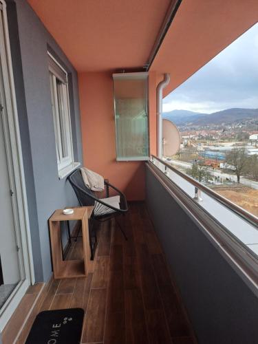 a room with a balcony with a chair and a window at Stan na dan Iv in Lukavica