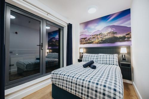 una camera da letto con un letto con una coperta a scacchi e finestre di Snoozles Galway City Centre a Galway