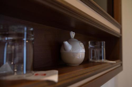 a vase sitting on a shelf with two glasses at Antica Piacenza in Piacenza