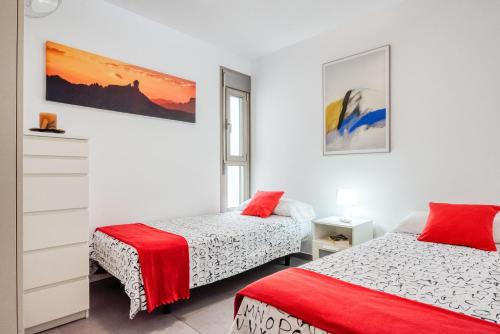 una camera con due letti e un dipinto sul muro di Mare Home - Beach & City a Las Palmas de Gran Canaria