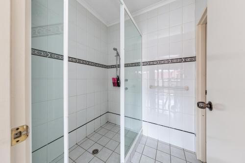 La salle de bains est pourvue d'une douche avec une porte en verre. dans l'établissement Tuggeranong Short Stay #10 - Sleeps 6, à Tuggeranong
