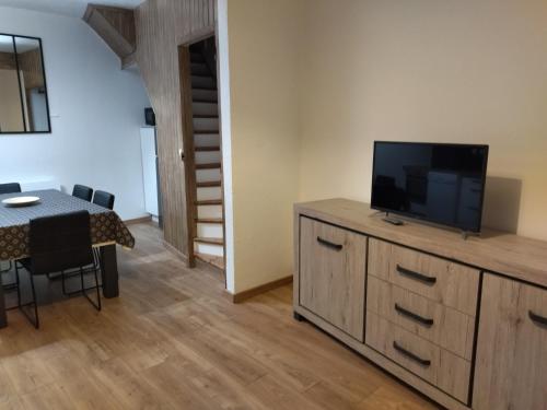 un salon avec une télévision sur une commode et une table dans l'établissement Les Hirondelles, à Berck-sur-Mer