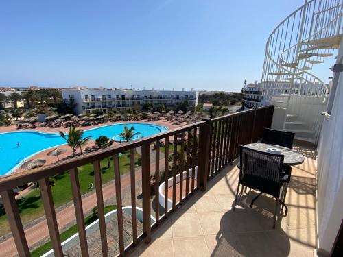balcón con mesa y vistas a la piscina en Apartments at Melia Beach Resort & Spa, en Santa Maria