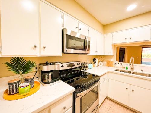 a kitchen with white cabinets and a black stove top oven at Stylish 2 bedroom near Ontario Airport in Fontana