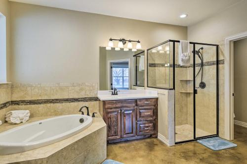 a bathroom with a tub and a shower and a sink at Secluded Krum Home with Patio and Gas Grill! in Krum